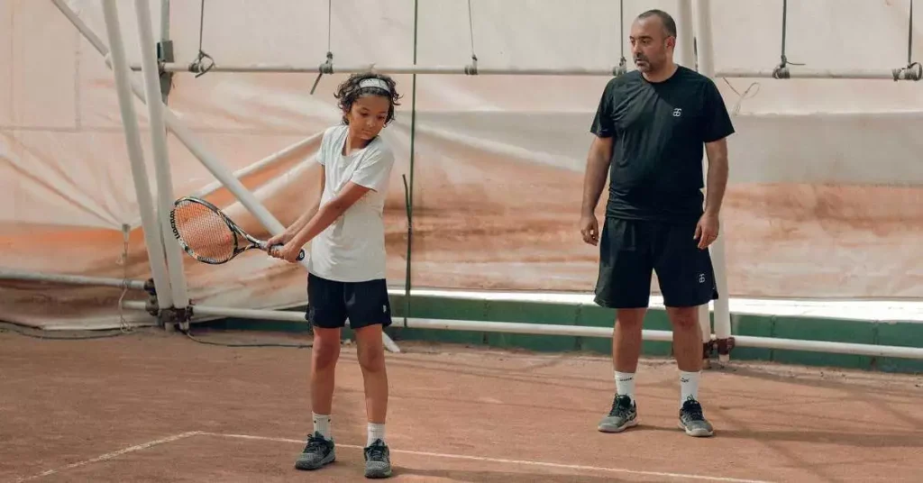 tennis coach coaching kid