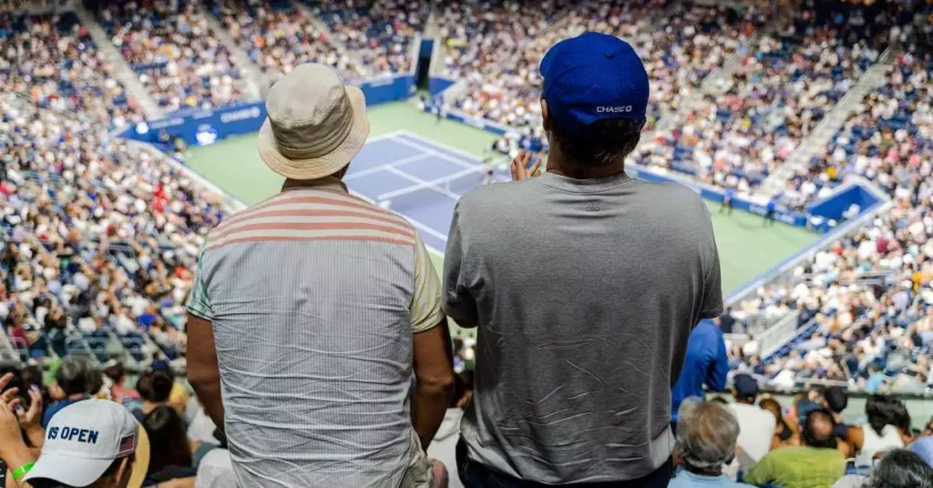 two spectators watching tennis tournament