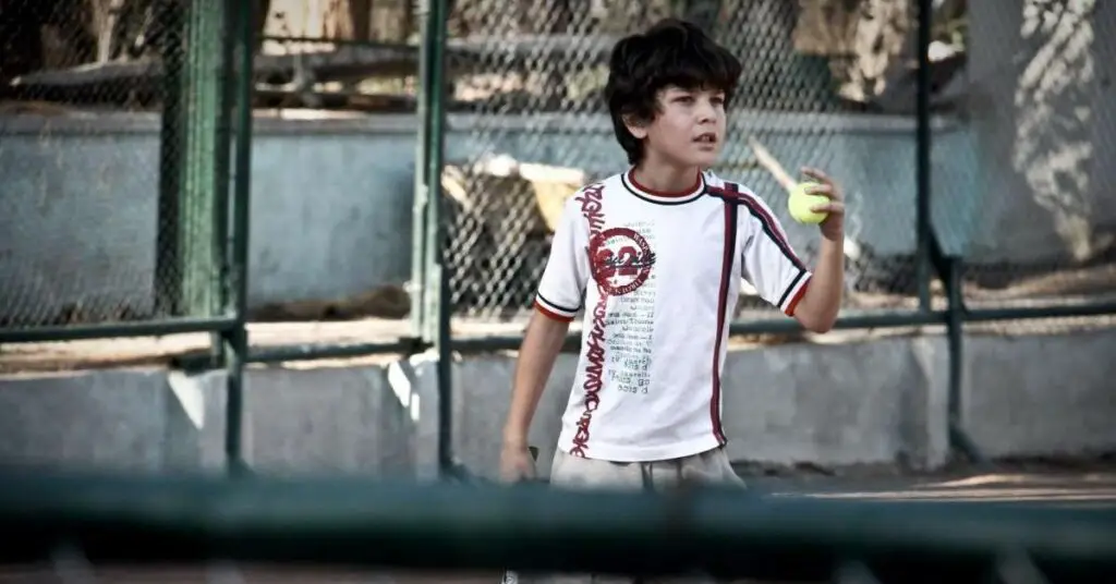 boy holding tennis ball
